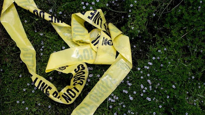 Yellow police crime scene tape rests in the grass on July 19, 2016 in Baton Rouge, Louisiana.