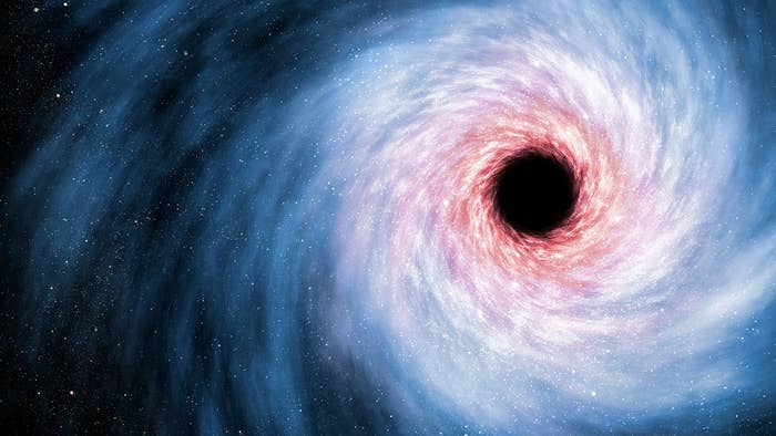 An artist&#x27;s illustration of a black hole per the Science Photo Library.