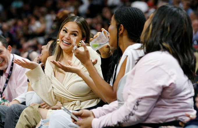 Chrissy Teigen reacts after Dwyane Wade crashed into her causing her