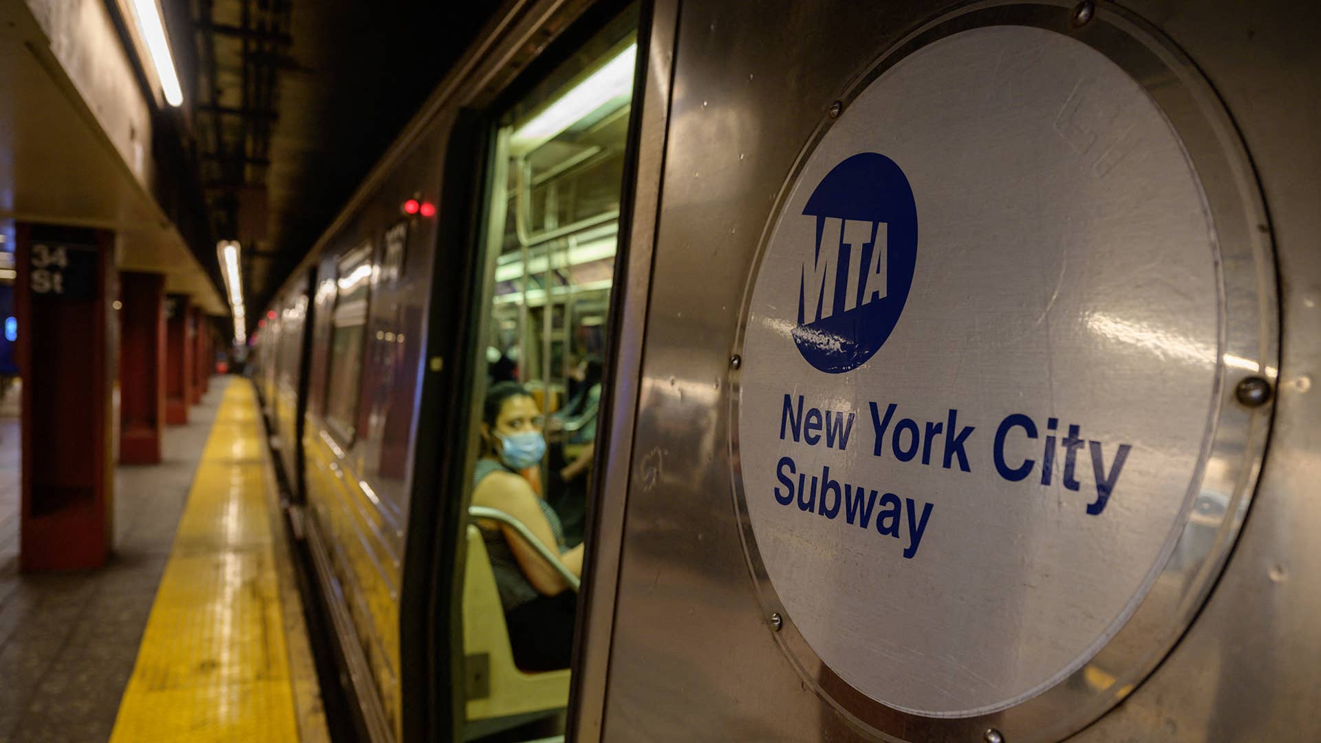 A Metropolitan Transportation Authority (MTA) logo is displayed on the side of a subway train in Manhattan, New York on June 2, 2021