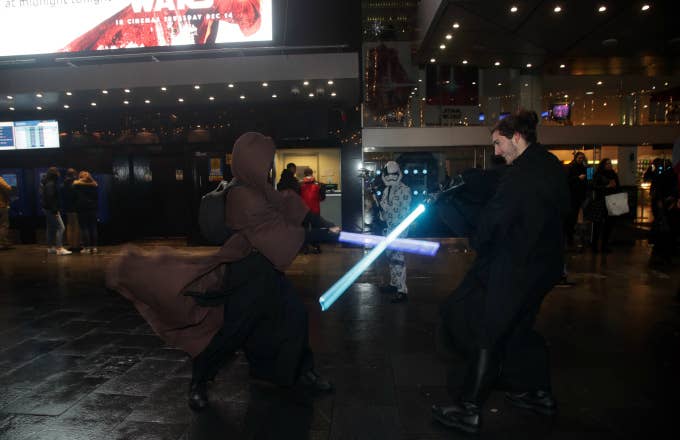 Fans in costume duel with lightsabers