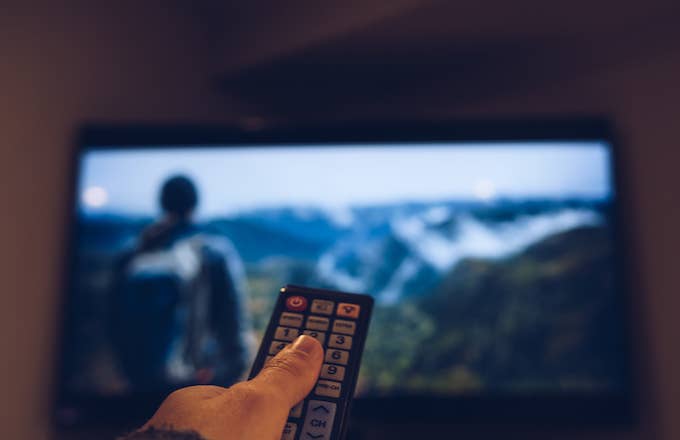 Image Of Hand Holding Remote Control In Front Of Television Set