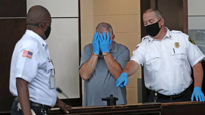 Patrick Rose covers his face during his arraignment at Boston Municipal Court in August 2020.