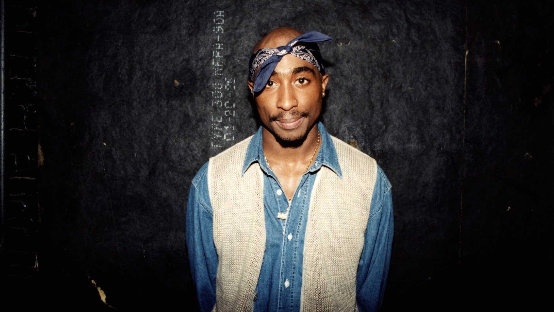 Rapper Tupac Shakur poses for photos backstage after his performance