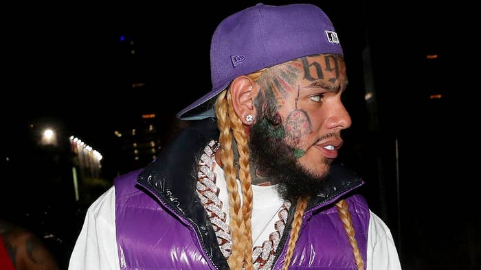 Musical artist 6ix9ine is pictured wearing a hat and vest