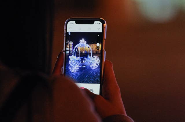 People are seen taking photos in a lit carriage on the Old Market Square in Bydgoszcz, Poland