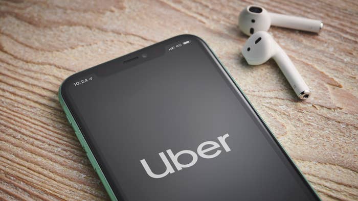 An Apple iPhone 11 smartphone with the Uber taxi app logo on screen.