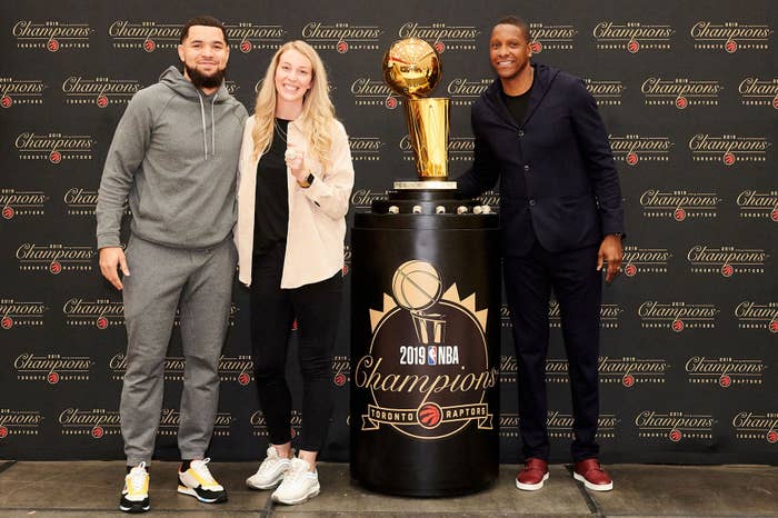 Toronto Raptors&#x27; Shelby Weaver poses with Fred VanVleet, Masai Ujiri, and the Larry O&#x27;Brien trophy