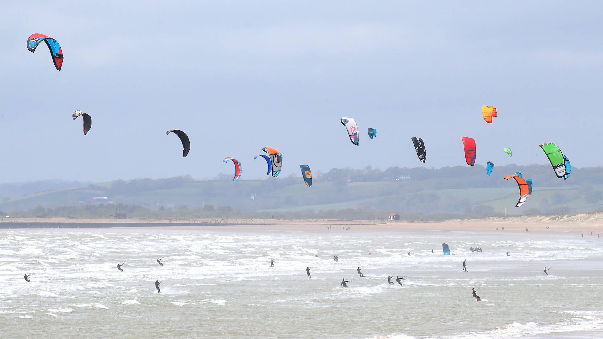 Kitesurfers enjoy with windy conditions in Camber, East Sussex