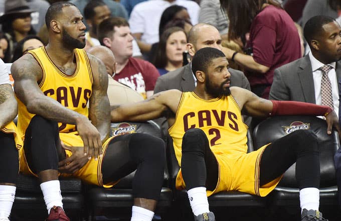 LeBron James and Kyrie Irving sit on the bench during a 2017 game.