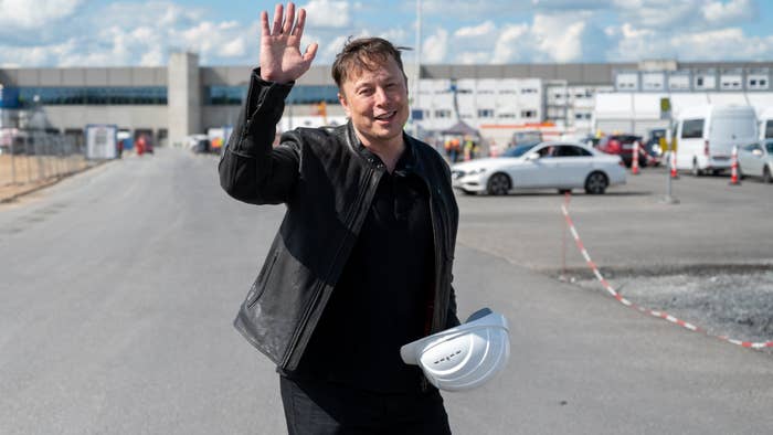 Elon Musk takes off a hardhat