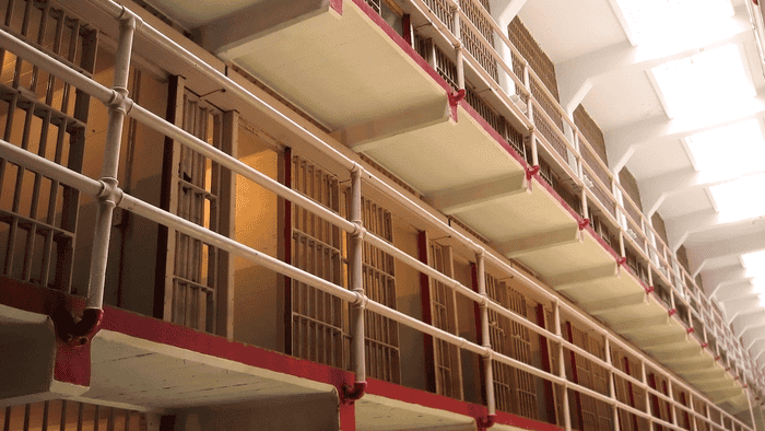 Shot of two levels of jail cells with doors open.