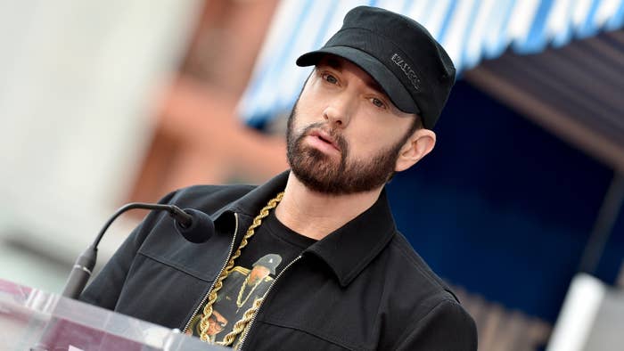 Eminem is pictured wearing a hat