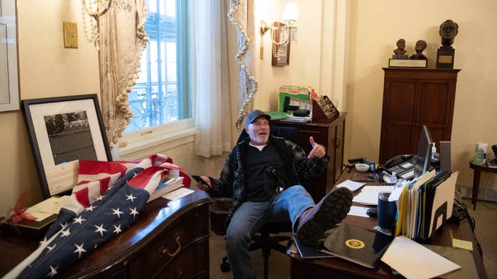 Richard Barnett sits inside the office of US Speaker of the House Nancy Pelosi.