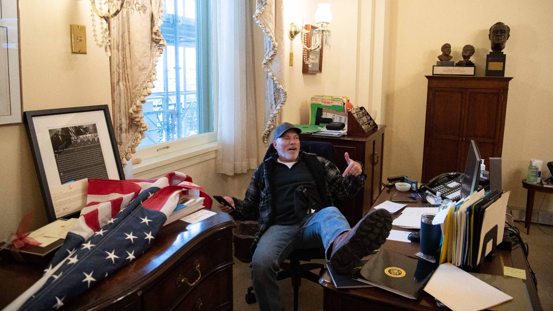 Richard Barnett sits inside the office of US Speaker of the House Nancy Pelosi.