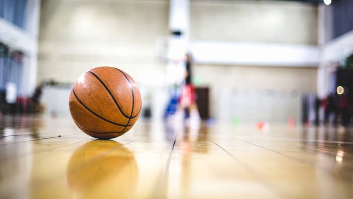 A basketball sat on an indoor basketball court.