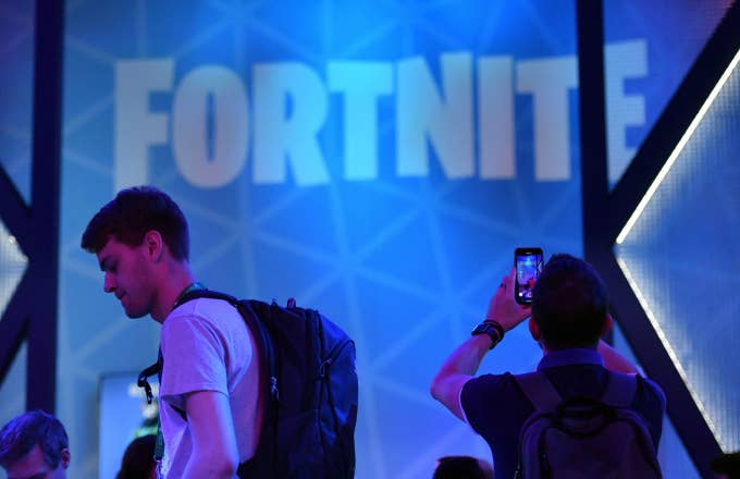 A visitor takes pictures at the stand of the "Fortnite" computer game