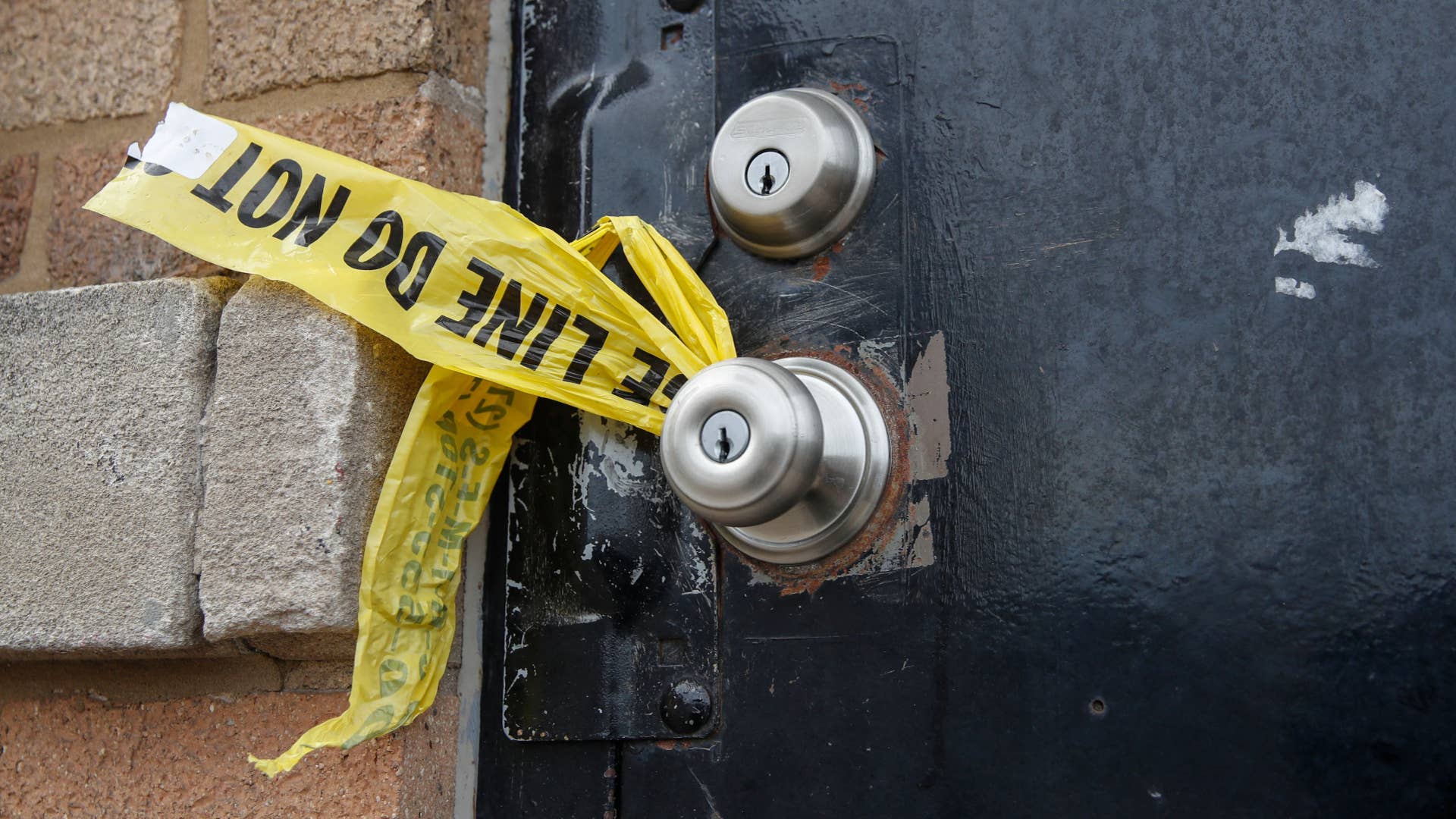 A piece of police caution tape is seen on the front door of the building where a shooting took place in Chicago.