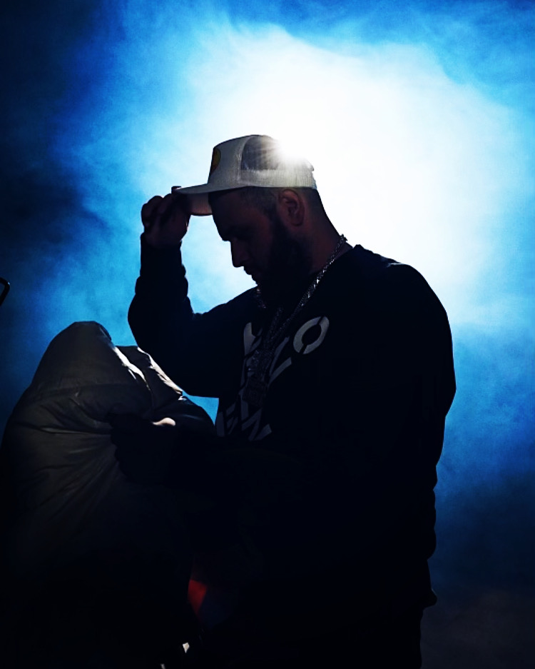 Toronto rapper Road Runner poses against blue background
