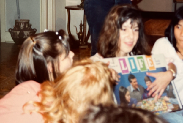 Group of people looking at a vintage LIFE board game with interest
