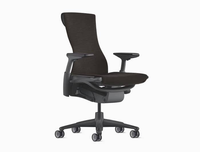 black office chair with a high backrest, adjustable armrests, and wheeled base