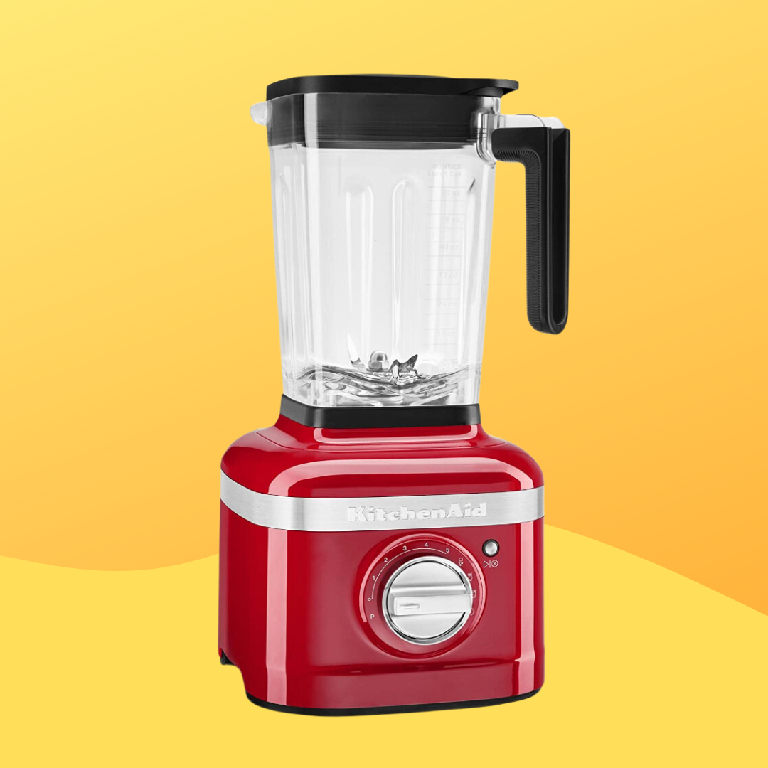 Red KitchenAid blender with a wide pitcher and metallic dial, connected a gradient background