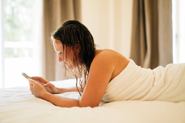 woman laying on a bed with wet hair