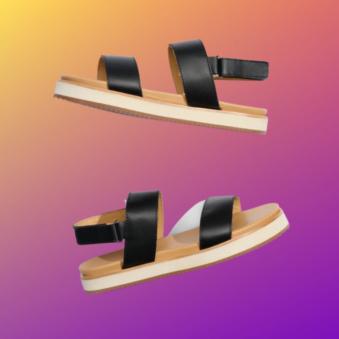 Black wide strap sandals against an ombre purple and yellow background