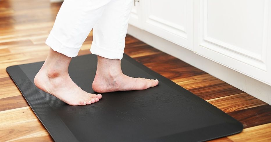 Person standing on a black anti-fatigue mat