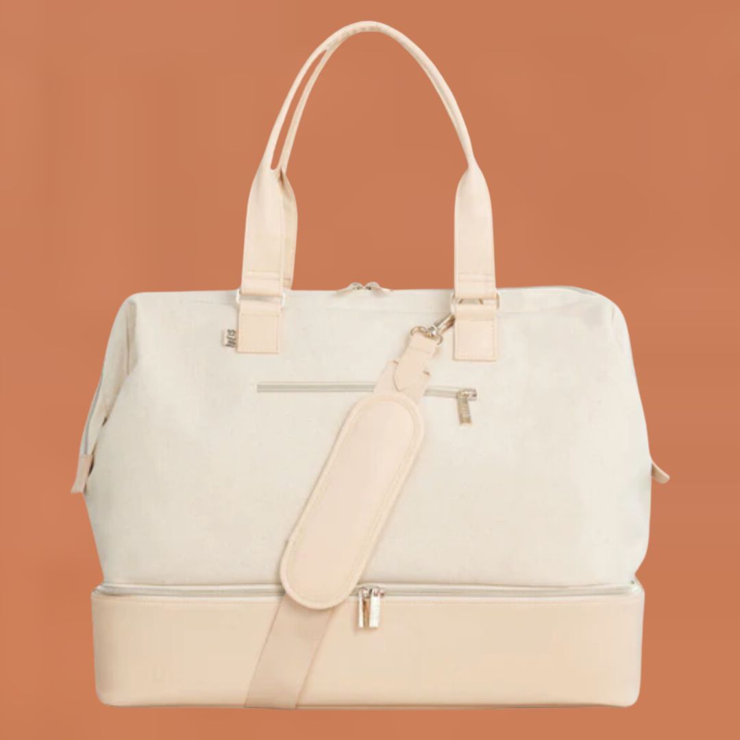 Cream-colored handbag with matching pouch and shoulder strap on a solid background