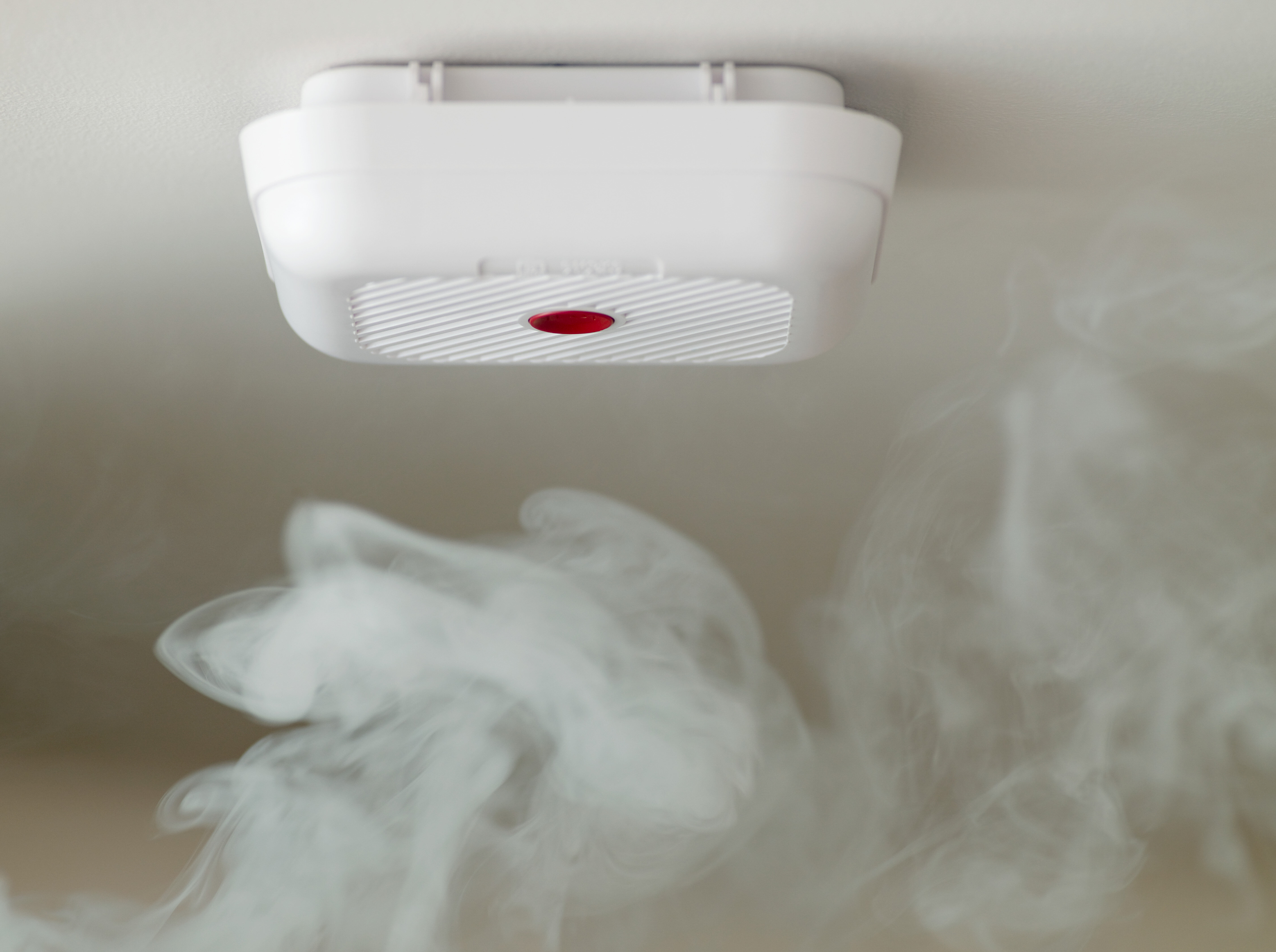 Smoke rising towards a ceiling-mounted smoke detector