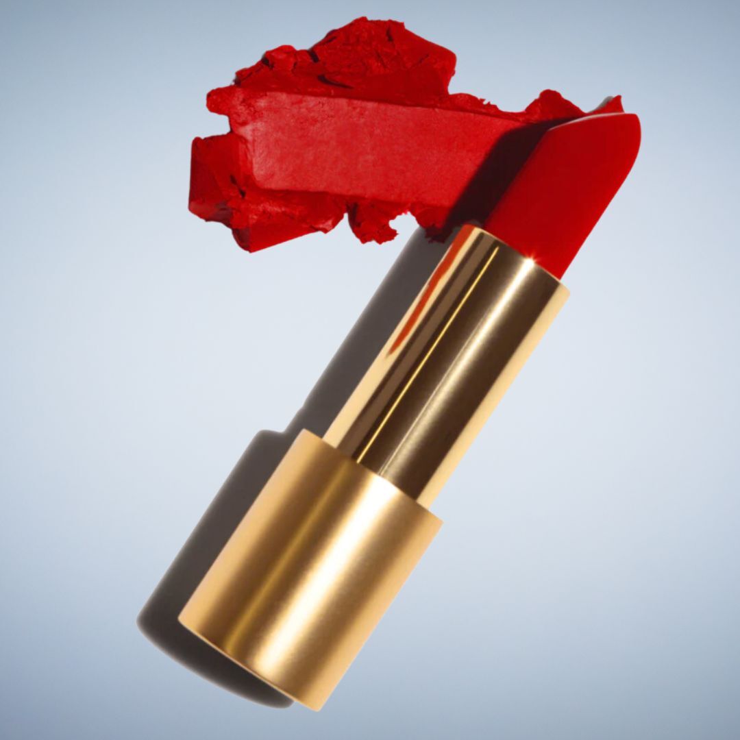 Red lipstick with a broken tip, contrasting with a neutral background, emphasizing the product&#x27;s texture