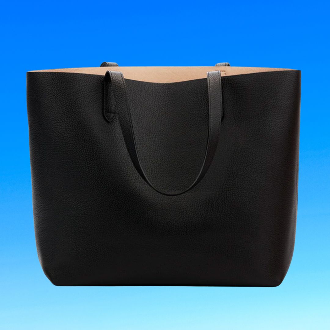 A black tote bag against a blue gradient background