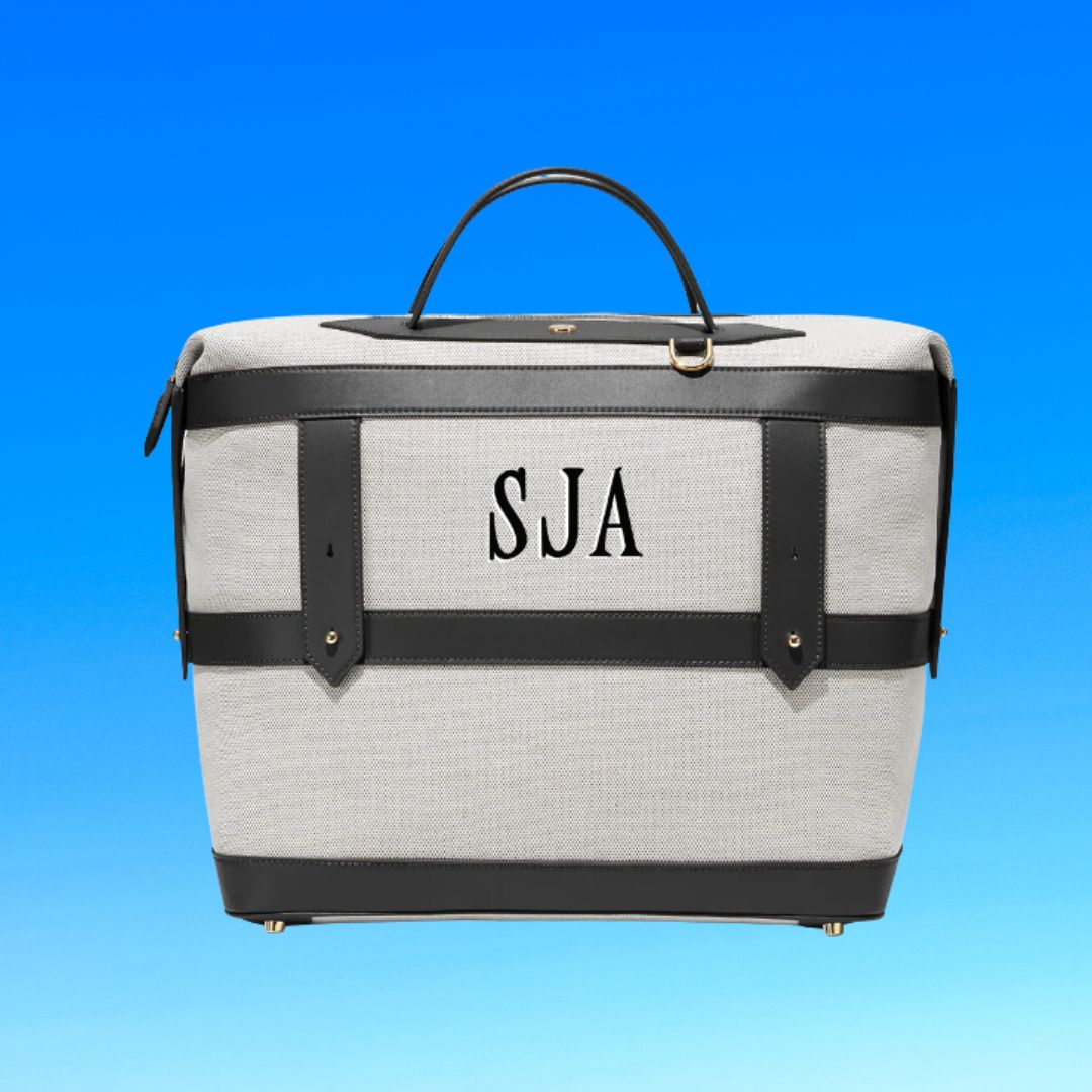 Monogrammed travel bag with initials &quot;SJA&quot; against a blue background