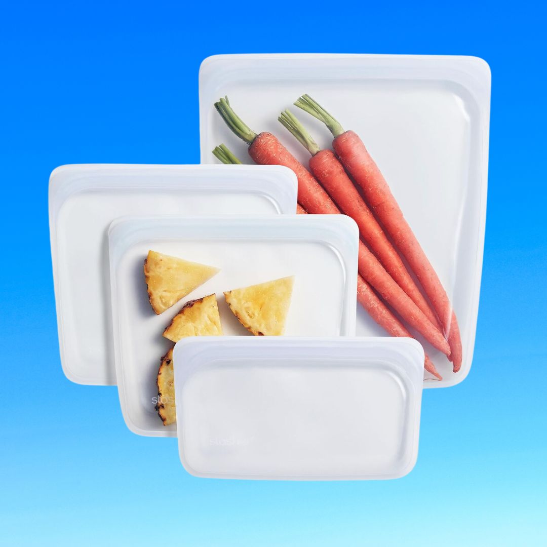 Different sized storage containers with lids, containing carrots and pie slices, floating against a blue backdrop