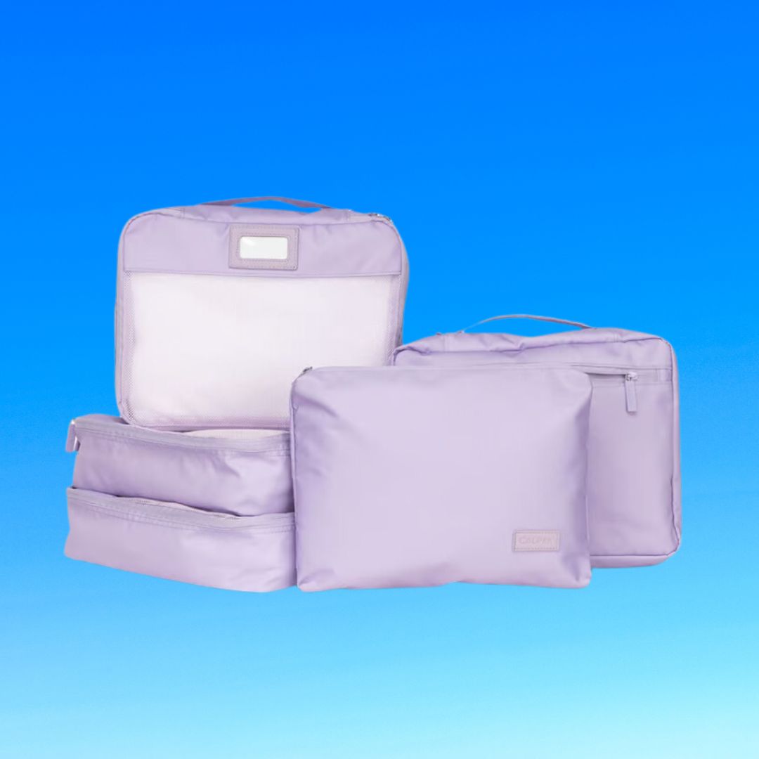 Three purple travel packing cubes of different sizes with zippers