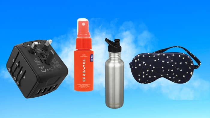 Various travel accessories including a power adapter, spray bottle, water bottle, and sleep mask against a blue background