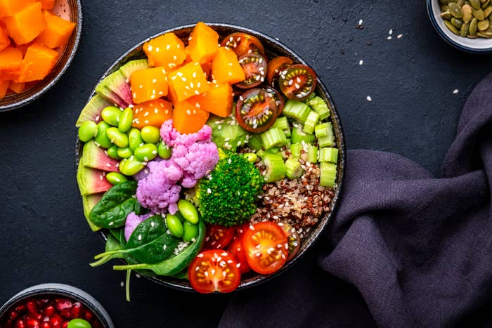 A bowl filled with various fresh vegetables and grains for a healthy meal