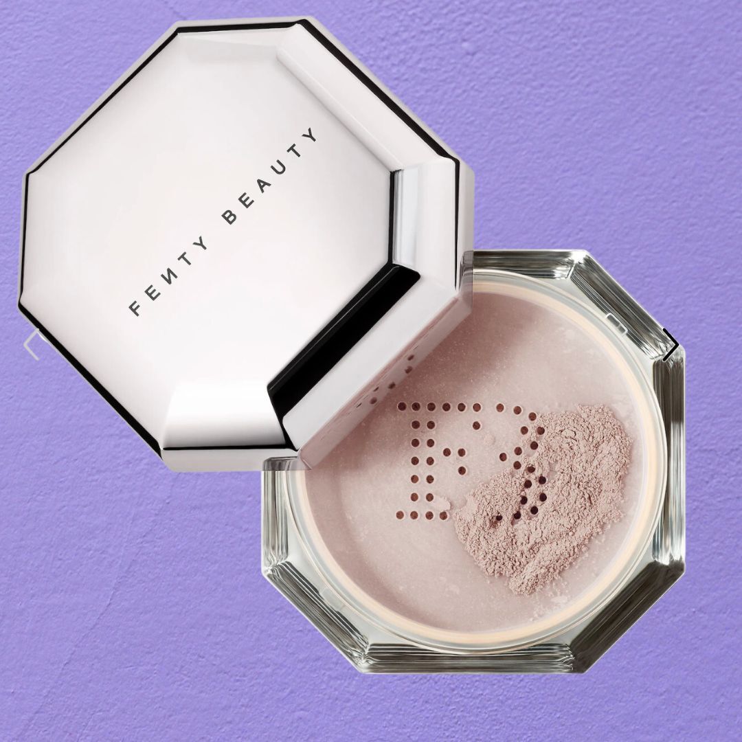 Fenty Beauty powder compact open on a purple background, showing the brand&#x27;s logo on the powder