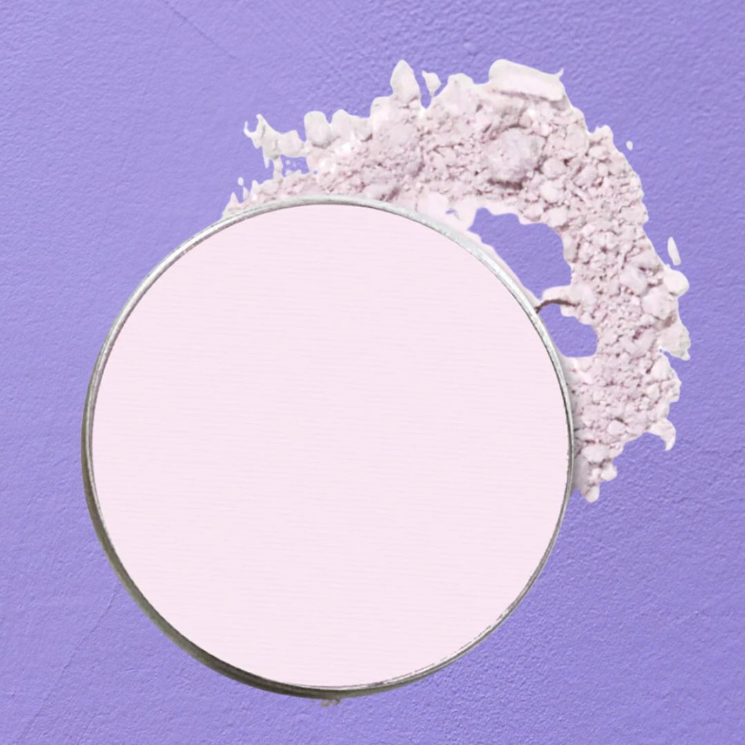 Compact powder with smudge on purple background, relevant for makeup shopping content