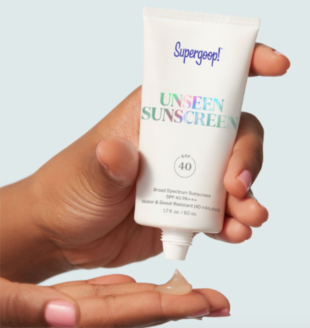 hands squeezing out sunscreen from its tube