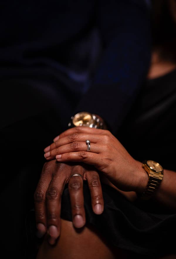 Close-up of two people holding hands, showcasing a wedding ring on one person #x27;s finger