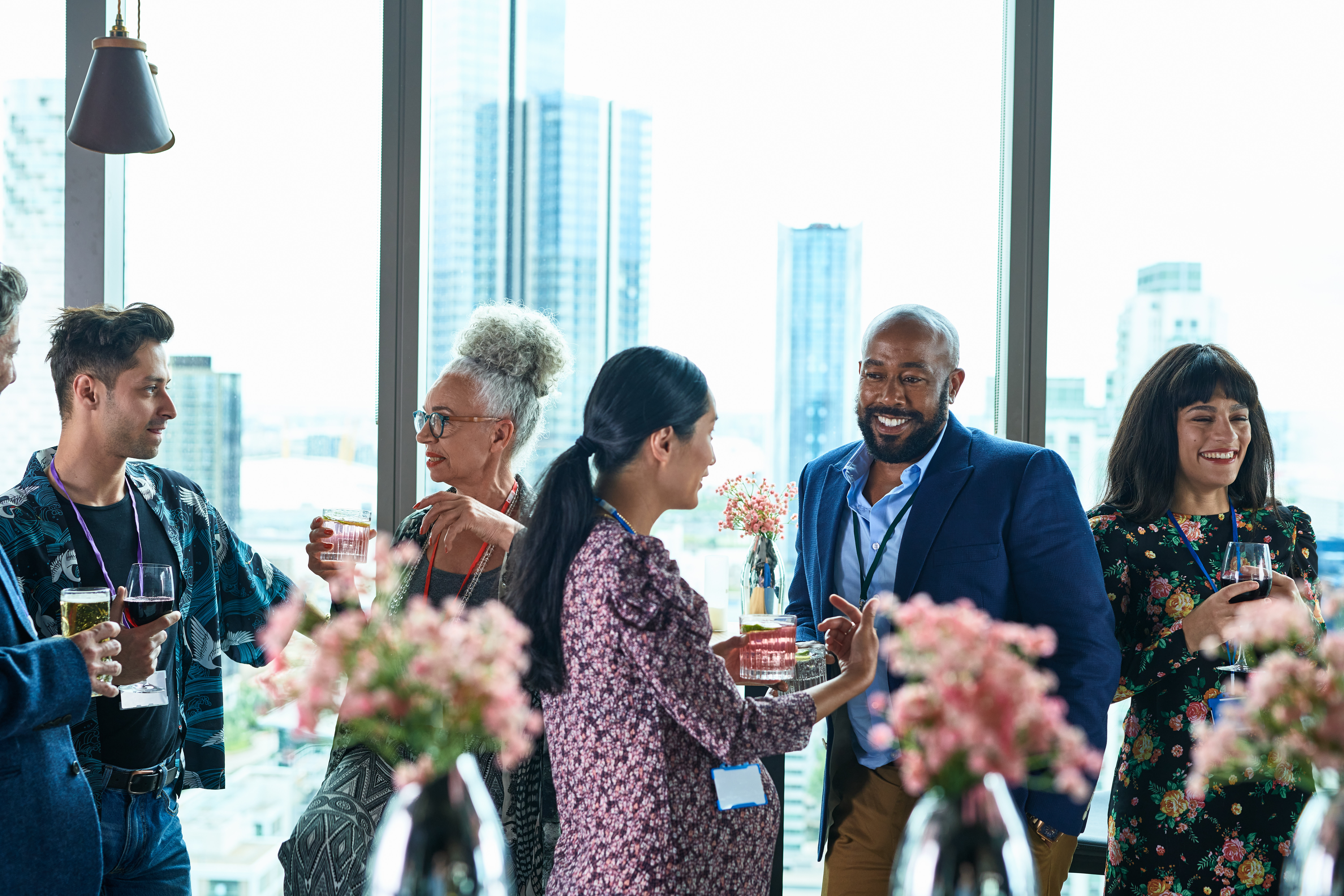 Professionals networking at an indoor event with cityscape in the background
