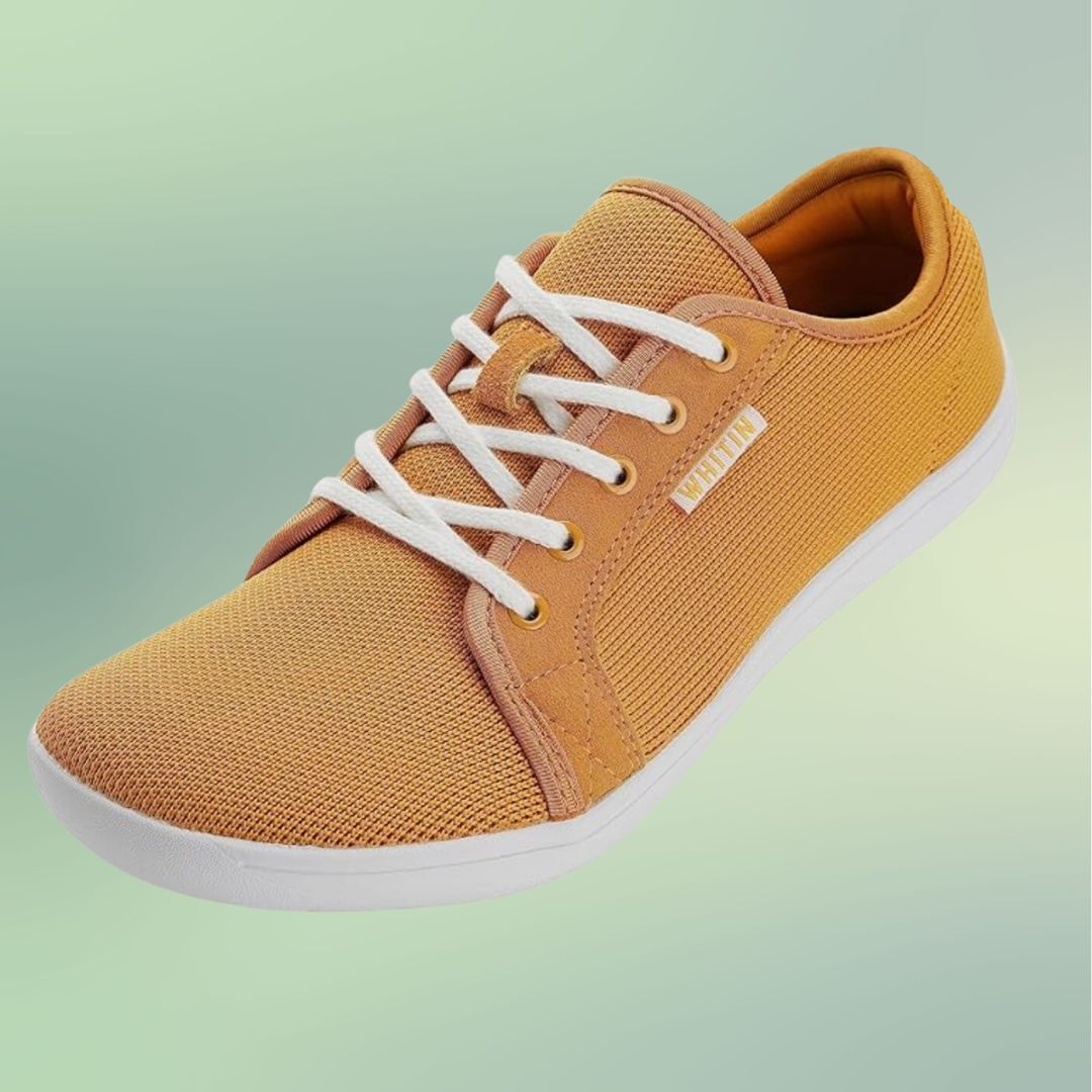 Orange sneaker with white laces on a green background