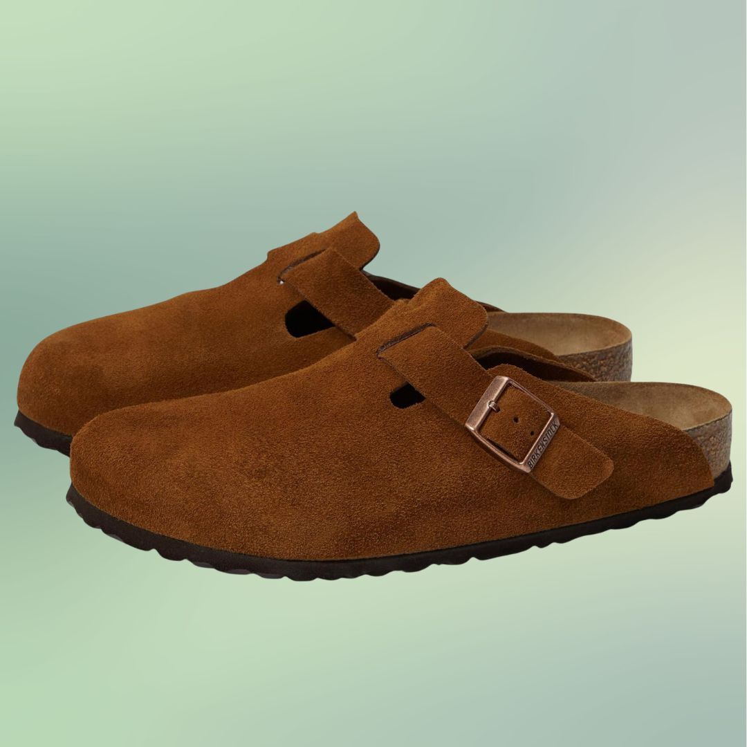 A pair of suede buckle-closure shoes on a plain background
