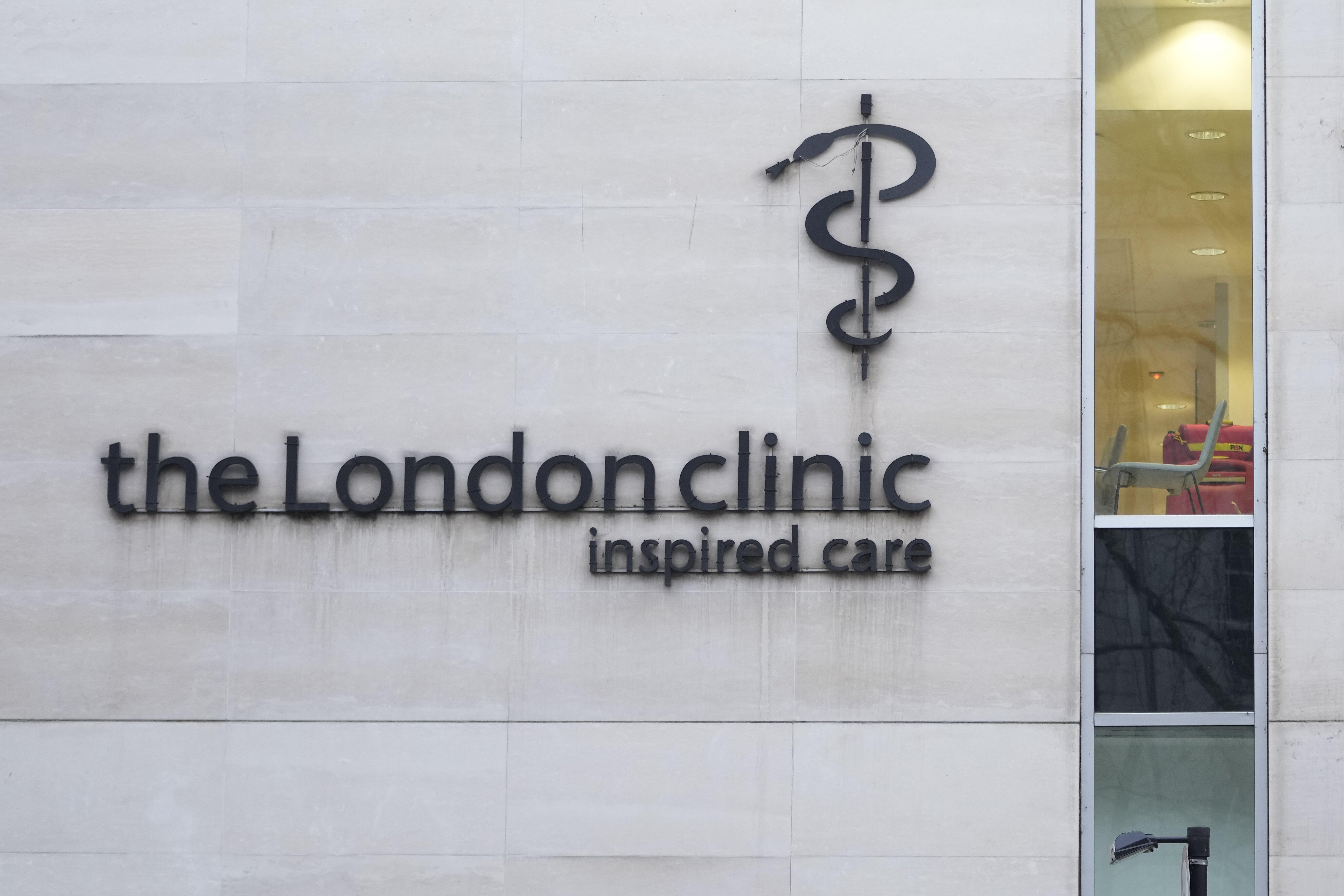 Signage of &quot;the London Clinic inspired care&quot; on a building wall with a view of a window and door