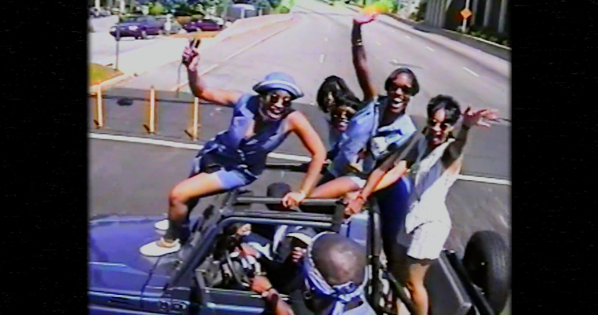 Group of people enjoying a ride on a car with open top, associated with lively music atmosphere