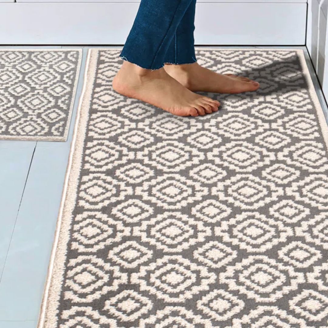 A person standing on a neutral-colored diamond patterned rug in a kitchen