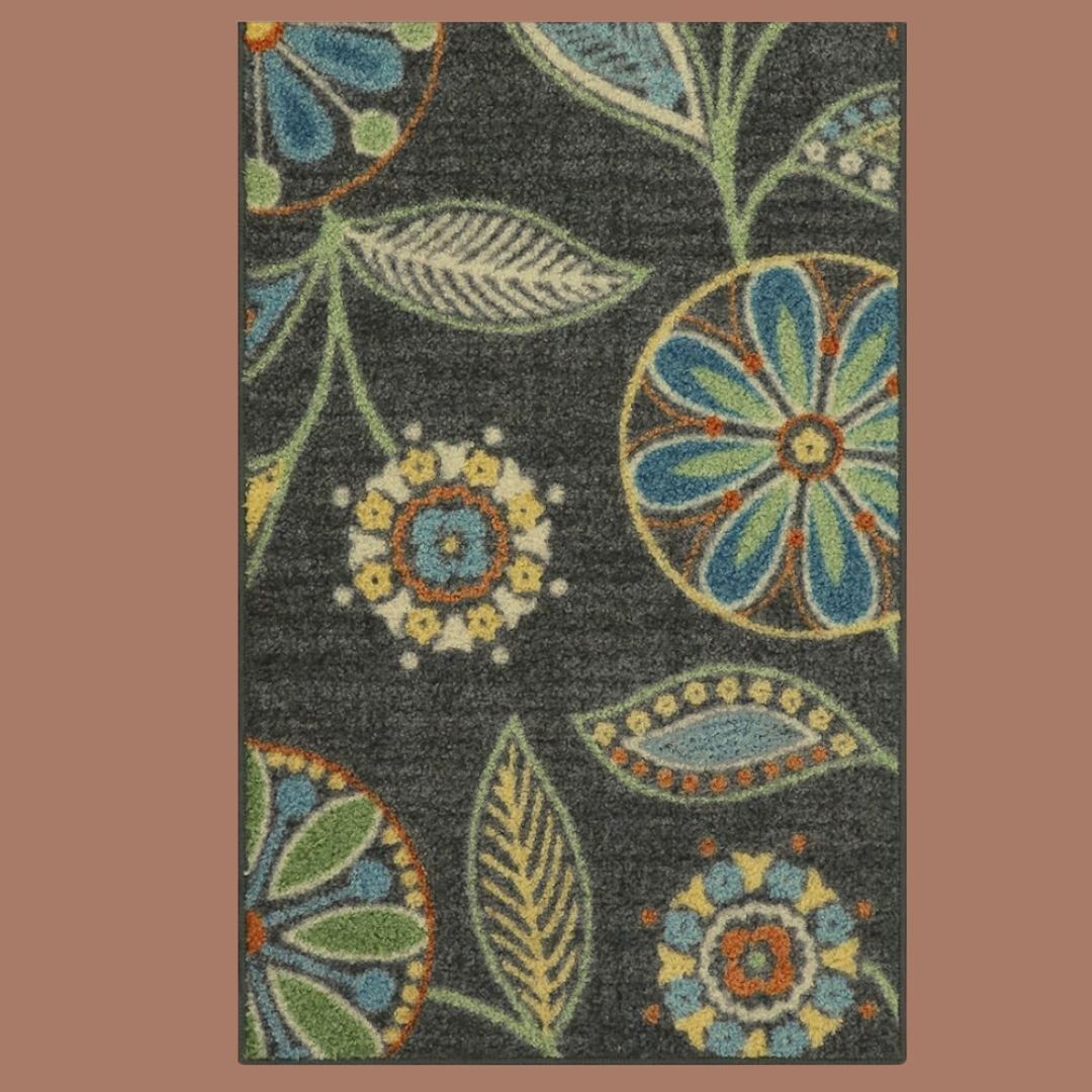 A black botanical patterned rug on a beige backjground