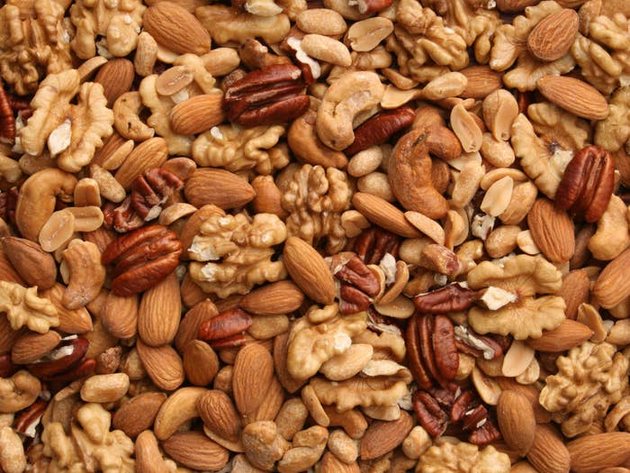 An assortment of shelled nuts including walnuts, pecans, almonds, peanuts, and cashews